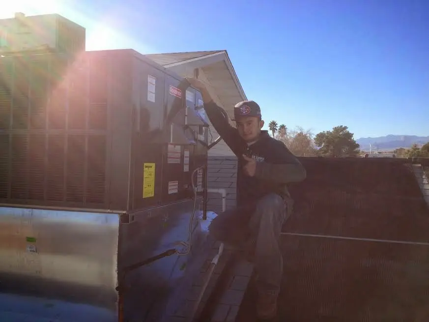 HVAC technician performing AC Tune-Up on a rooftop unit in Harrington Park